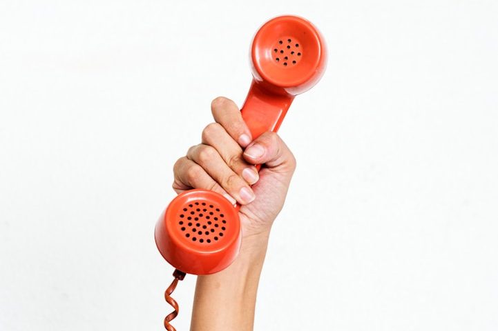 Roter Telefonhörer in einer Hand